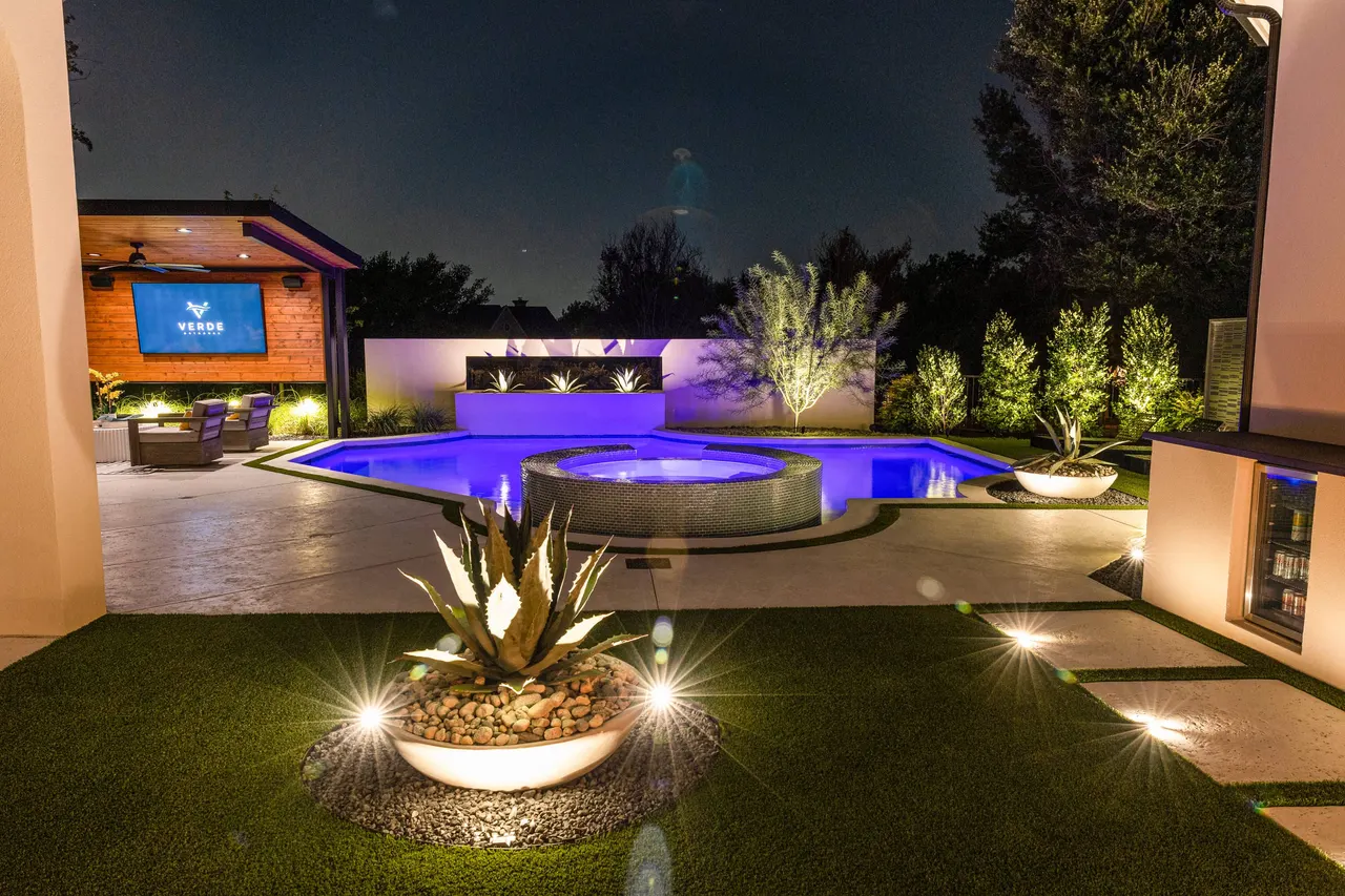 Custom pool with LED lighting and fire features at night, Dallas–Fort Worth
