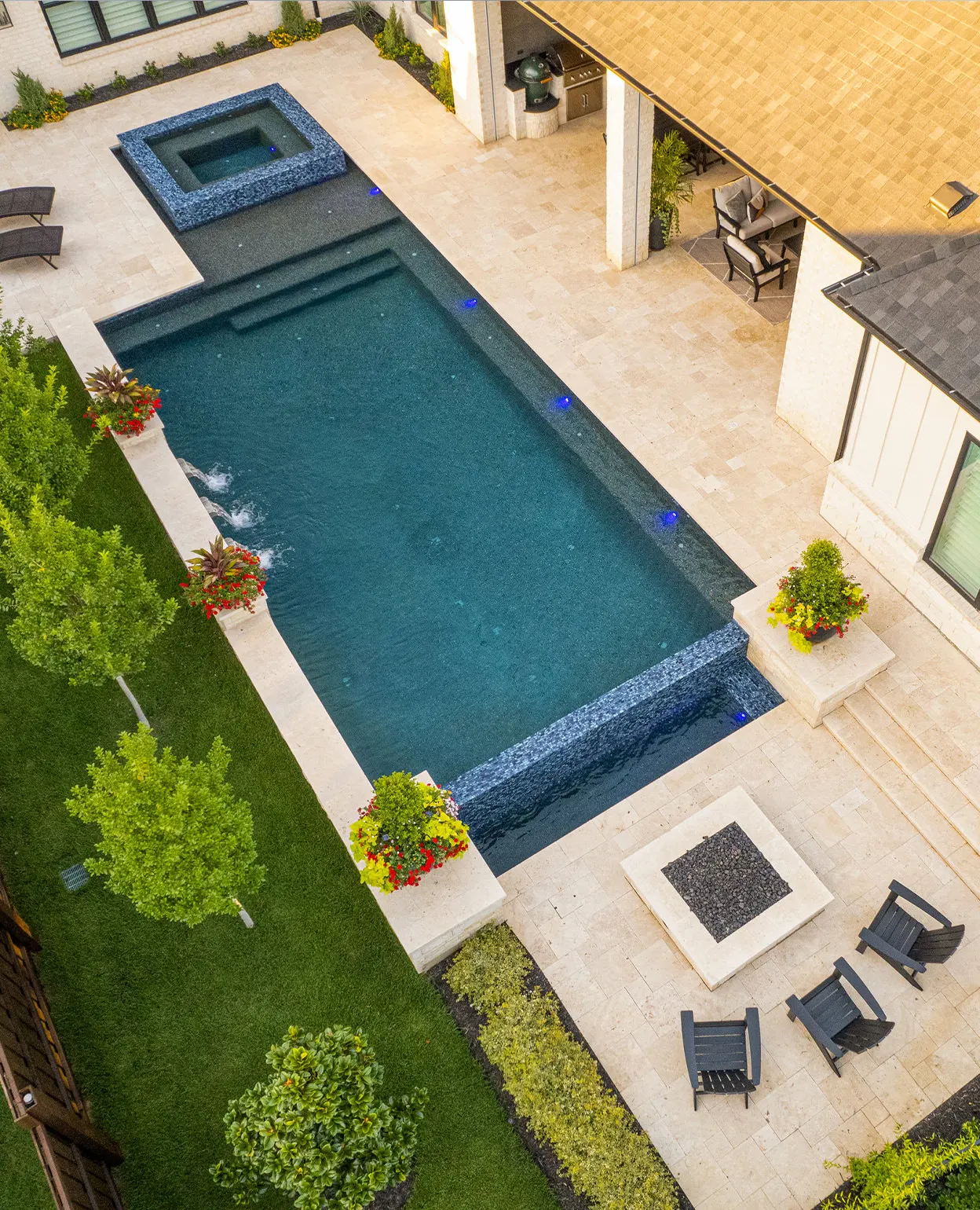 Custom pool with raised spa and wall water feature by Verde Outdoors