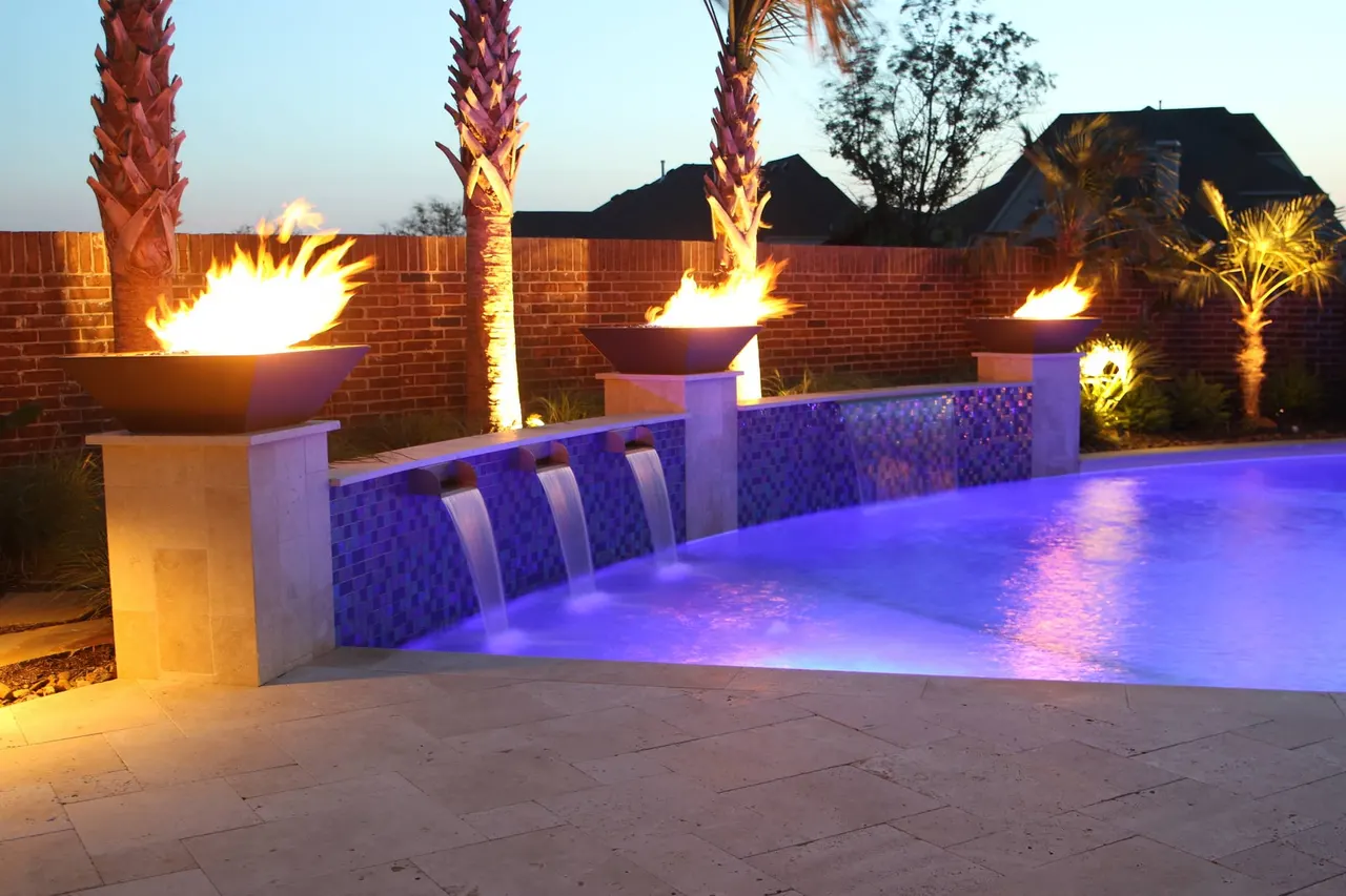 Fire bowls and water features on a custom pool by Verde Outdoors