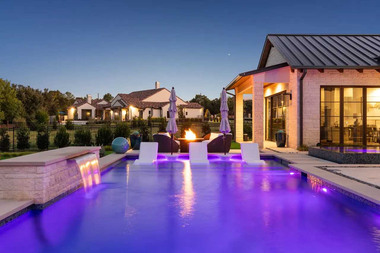 Custom pool with LED lighting and fire features at dusk — Oak Alley Sports Retreat, Colleyville TX
